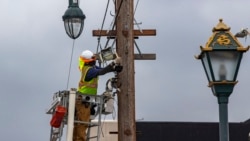 AT&T workers wear face masks during the coronavirus pandemic as they deploy fiber optic lines for a cell phone tower station in the Chinatown neighborhood of Los Angeles, Friday, June 5, 2020. (AP Photo/Damian Dovarganes)