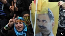 Jineke Kurd wêneya rêberê PKK'ê Abdullah Ocalan bilind dike. Stenbol, Nîsan 19, 2011