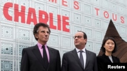 French President Francois Hollande (center) with Culture minister Fleur Pellerin (Right) and the President of the Institut du Monde Arabe (Arab institute), Jack Lang walk near the Arab Institute building in Paris.