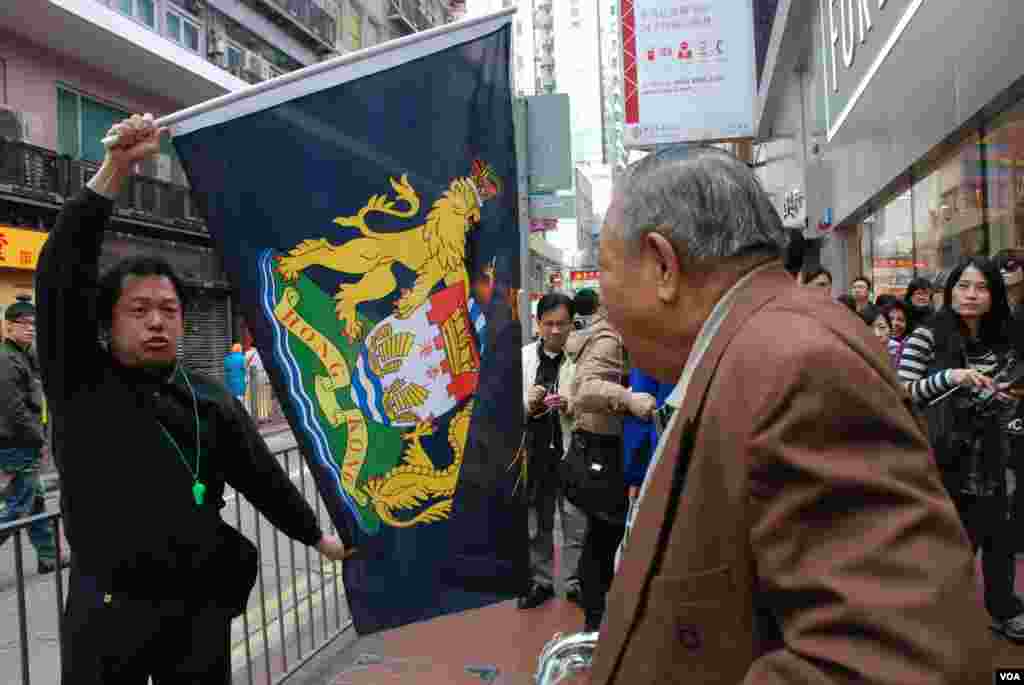 有參加「倒梁」遊行的示威者高舉港英殖民時期的「龍獅旗」,抗議香港主權移交中國15年,香港政府管治今不如昔,有途人質疑示威者否認中國人的身分(美國之音湯惠芸攝)
