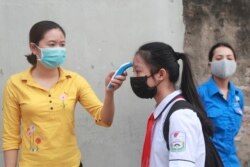 A student is scanned for temperature before entering Dinh Cong secondary school in Hanoi, Vietnam Monday, May 4, 2020.