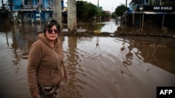 ARCHIVO - Orioplina Bechiln, una vendedora ambulante de barbacoas, camina por una calle inundada alrededor del estadio Arena do Gremio en Porto Alegre, estado de Rio Grande do Sul, Brasil, el 29 de mayo de 2024.