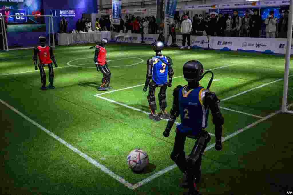 Robots from Booster Robotics play football during the Global Developer Conference, organized by the Shanghai AI Industry Association, in Shanghai. (Photo by Hector RETAMAL / AFP)