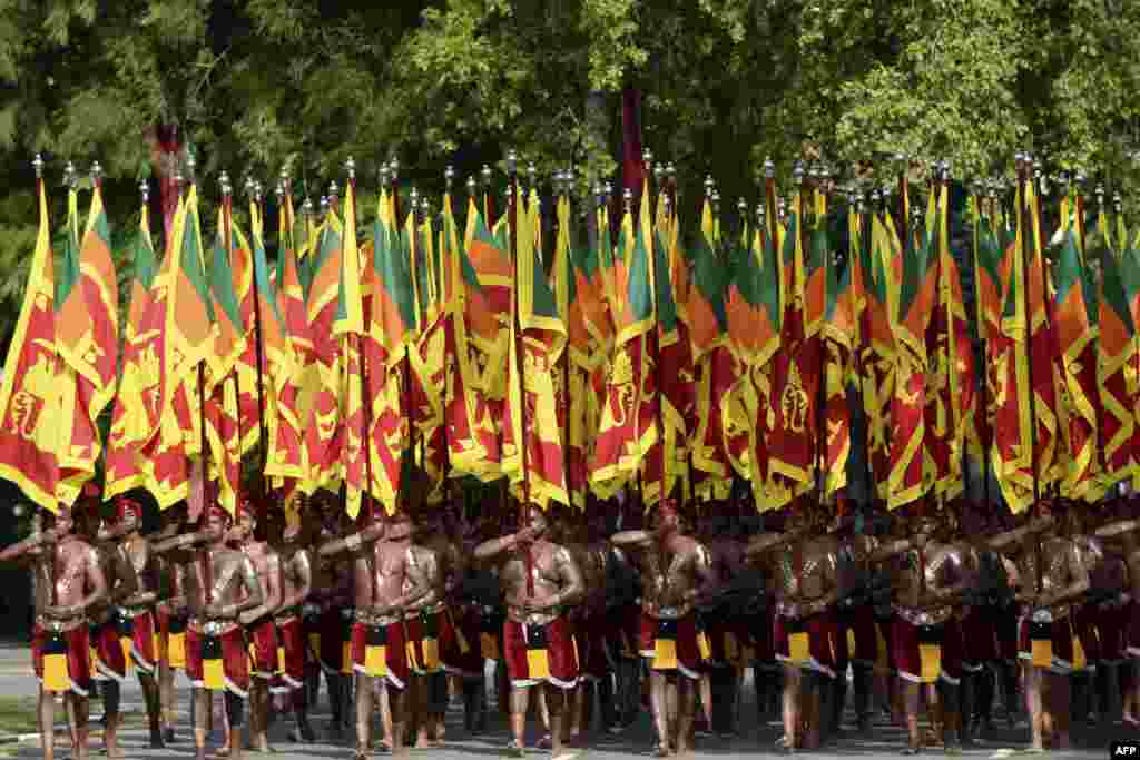 Sri Lankan military personnel with the army cultural troupe march wearing traditional dresses and holding national flags during the country&#39;s 73rd Independence Day celebrations in Colombo.