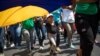 Una niña avanza mientras ayuda a sostener una bandera en una marcha progubernamental en el Día Internacional de la Mujer en Caracas, el 8 de marzo de 2020.