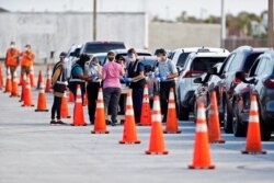 Florida Department of Health medical workers prepare to administer a COVID-19 vaccine to seniors in the parking lot of the Gulf View Square Mall in New Port Richey near Tampa, Florida, Dec. 31, 2020.