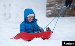 This child is bundled up against the cold in Aviemore, Scotland, December 2017. (REUTERS/Russell Cheyne)