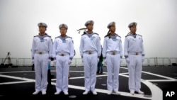 Chinese sailors stand on the deck of the naval training ship Qi Jiguang during a naval parade to commemorate the 70th anniversary of the founding of China's PLA Navy in the sea near Qingdao in eastern China's Shandong province, Tuesday, April 23, 2019.