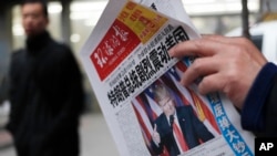 A man reads a newspaper with the headline of "U.S. President-elect Donald Trump delivers a mighty shock to America" at a news stand in Beijing, Thursday, Nov. 10, 2016.