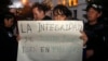 Una mujer sostiene un cartel que dice "La seguridad de Assange está en peligro" mientras se manifiesta en contra del arresto del fundador de WikiLeaks, Julian Assange, frente al Ministerio de Relaciones Exteriores en Quito.