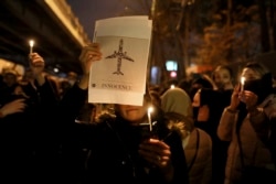 People gather for a candlelight vigil to remember the victims of the Ukraine plane crash, at the gate of Amri Kabir University that some of the victims of the crash were former students of, in Tehran, Iran, Saturday, Jan. 11, 2020.