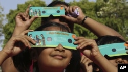 Indian children in Allahabad use cardboard eclipse glasses as they prepare to watch the transit of Venus on Tuesday