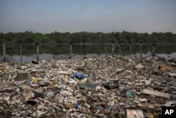 FILE: Trash floats on a polluted water channel that flows into the Guanabara Bay in Rio de Janeiro, Brazil, on May 15, 2014 .