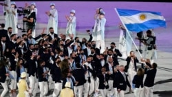 Cecilia Carranza Saroli and Santiago Raul Lange, of Argentina, right, carry their country's flag during the opening ceremony in the Olympic Stadium at the 2020 Summer Olympics, Friday, July 23, 2021, in Tokyo, Japan. (AP Photo/Patrick Semansky)