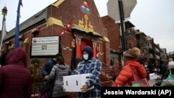 People receive free food from the United Sherpa Association's weekly food pantry on Friday, January 15, 2021, in Queens, New York. (AP Photo/Jessie Wardarski)