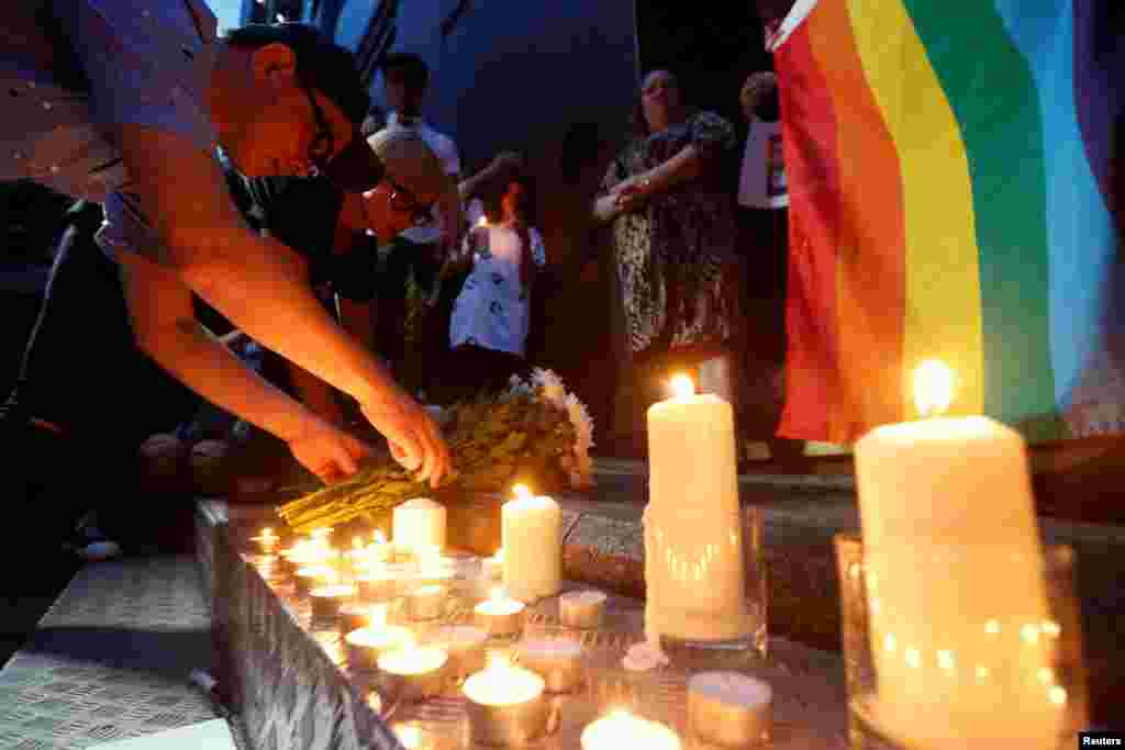Singers Anthony Wong, left, and Denise Ho lay flowers during a candlelight vigil to mourn victims of the Pulse Orlando shooting, Hong Kong, China, June 13, 2016. 
