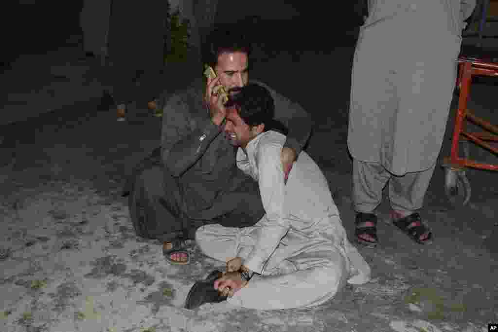 A Pakistani comforts to another mourning over the death of his family member in a bomb blast, at a hospital in Quetta, April 21, 2021. A powerful bomb went off in the parking area of a five-star Serena hotel in the southwestern city, wounding some people, police said.