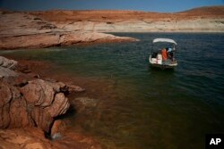 A Utah State University research team works at Lake Powell on June 7, 2022, in Page, Arizona. (AP Photo/Brittany Peterson, File)