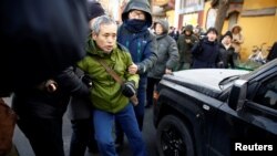 中国警察把一名正在天津法庭外支持维权律师王全璋的支持者抓走塞入警车。（2018年12月26日）
