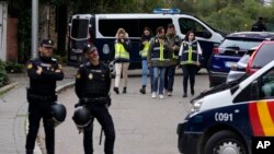 ARCHIVO - Oficiales de policía hacen guardia mientras otros agentes con chalecos amarillos trabajan en el área acordonada junto a la embajada de Ucrania en Madrid, España, el 30 de noviembre de 2022, luego de informes de una explosión en la embajada de Ucrania. 