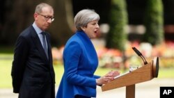 British Prime Minister Theresa May speaks watched by her husband Philip in 10 Downing street, London, as she addresses the press Friday, June 9, 2017 following an audience with Britain's Queen Elizabeth II at Buckingham Palace. (AP Photo/Tim Ireland)