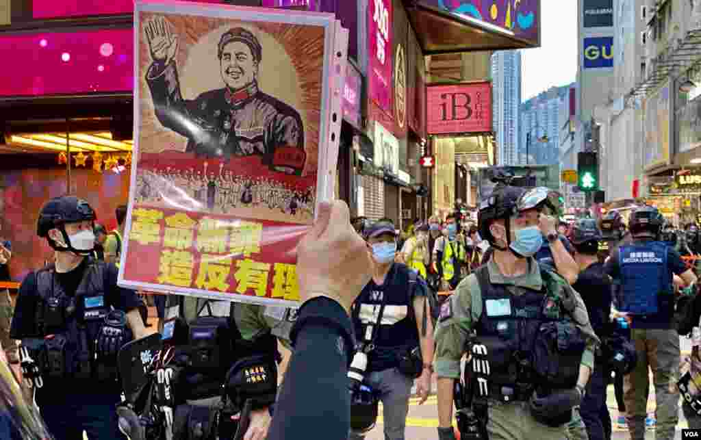 有香港市民10月1日下午在銅鑼灣崇光百貨附近,對著警方封鎖線高舉文化大革命標語。(美國之音湯惠芸)