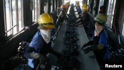Công nhân phân loại than tại một nhà máy chế biến than ở mỏ than lộ thiên Cốc 6 ở thị xã Cẩm Phả, tỉnh Quảng Ninh. Việt Nam hiện chủ yếu dựa vào than và thủy điện để cung cấp năng lượng cho nền kinh tế đang phát triển nhanh chóng.