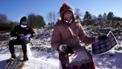 Fourth grader Falis Asair is taking notes about snowflakes during an outdoor class at the Gerald Talbot School, in Portland, Maine. Photo taken on Monday, December 8, 2020. (AP Photo/Robert F. Bukaty)