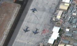 A view of people waiting in line to board the C-17 Globemaster III aircraft at the Hamid Karzai International Airport, in Kabul, Afghanistan August 27, 2021. Satellite image 2021 Maxar Technologies/Handout via REUTERS