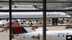 Delta Air Lines planes are seen on the tarmac at Washington's Ronald Reagan Washington's National Airport, Monday, Aug. 8, 2016. (AP Photo/Carolyn Kaster)