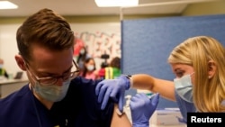 FILE PHOTO: Fourth-year medical student Anna Roesler administers the Pfizer-BioNTech coronavirus disease (COVID-19) vaccine at Indiana University Health, Methodist Hospital in Indianapolis, Indiana, U.S., December 16, 2020. REUTERS/Bryan Woolston