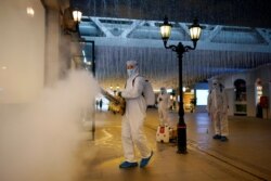 Volunteers in protective suits disinfect a shopping complex in Wuhan, Hubei province, the epicentre of China's coronavirus disease (COVID-19) outbreak, March 31, 2020. REUTERS/Aly Song