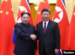 中共中央总书记、国家主席习近平和鲜劳动党委员长、国务委员会委员长金正恩在北京人民大会堂握手（2018年3月28日发布的照片）