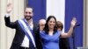 El recién juramentado presidente de El Salvador, Nayib Bukele, y su esposa Gabriela saludan durante las actividades inaugurales en la Plaza Barrios en San Salvador, el sábado 1 de junio de 2019. 