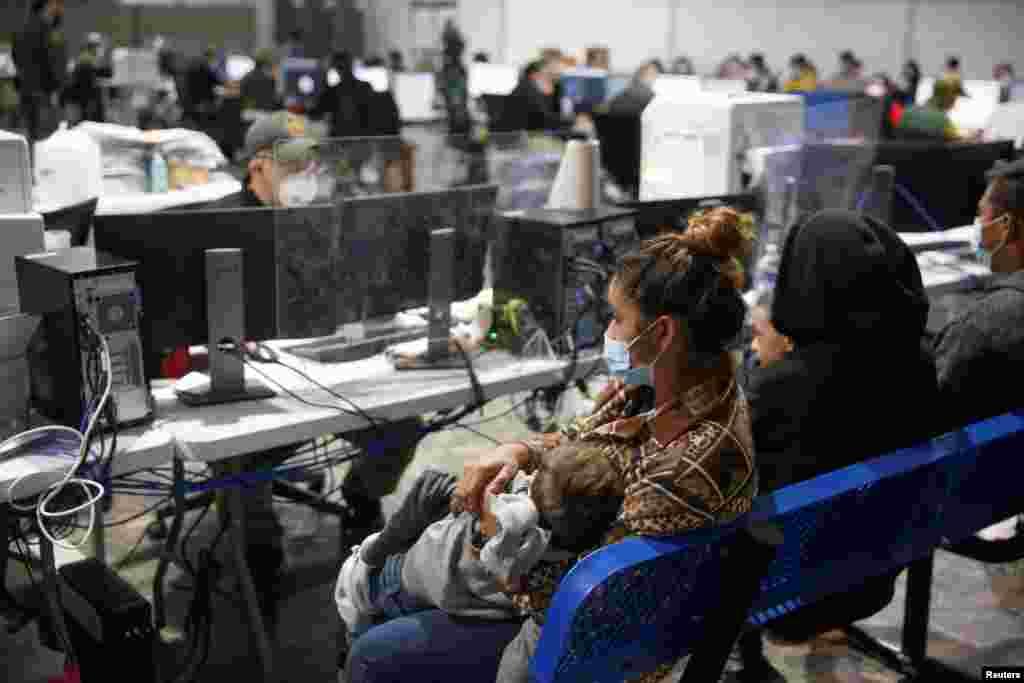 Las familias migrantes esperan ser interrogadas en el área de admisión preliminar del centro de detención del Departamento de Seguridad Nacional de Donna.