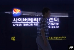 FILE - A man walks by a sign at Cyber Terror Response Center of National Police Agency in Seoul, South Korea, July 16, 2013. North Korea is accused of using cyberattacks against South Korea and 16 other countries to benefit its nuclear program.