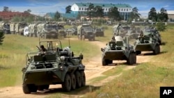 In this frame grab provided by Russian Defense Ministry Press Service on Tuesday, Sept. 11, 2018, Russian armored personnel carriers roll during the military exercises in the Chita region, Eastern Siberia, during the Vostok 2018 exercises in Russia. (Russian Defense Ministry Press Service pool photo via AP) 