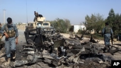 FILE - Afghan security forces inspect the site of a U.S. airstrike in Kunduz city, north of Kabul, Afghanistan, Oct. 2, 2015.