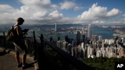 A tourist takes a picture from the Victoria Peak in Hong Kong.