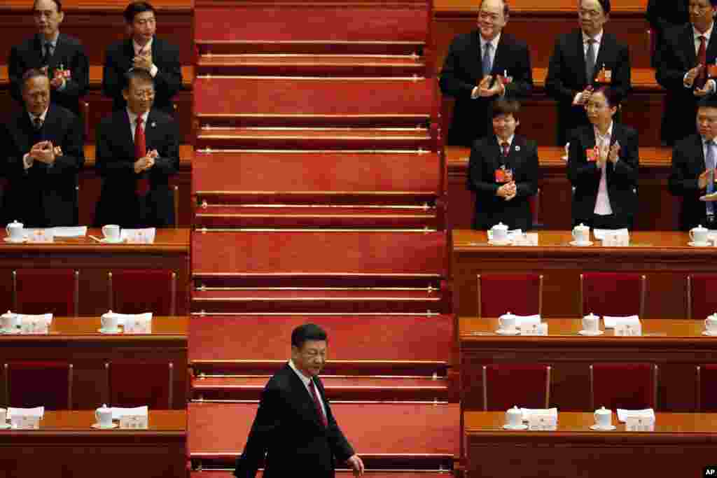 中国国家主席习近平2018年3月5日步入北京人民大会堂的会场,参加全国人大开幕式。图片显示,主席台后面几排的人已经各就各位,起立迎接前几排的高官们,习近平率先进场,其他高官和习近平之间保持一段距离。
