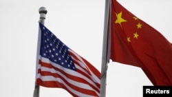 资料照片：美中国旗在一家美国公司驻北京的办公楼外飘扬。（2021年1月21日）