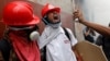 Manifestantes opositores tratan de limpiar de gas lacrimógeno a un compañero durante choques con la policía en Caracas el 3 de mayo.