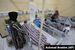 Relatives stand nearby as survivors of Saturday's deadly crush are treated at a hospital in Malang, East Java, Indonesia, on October 3, 2022. (AP Photo/Achmad Ibrahim)