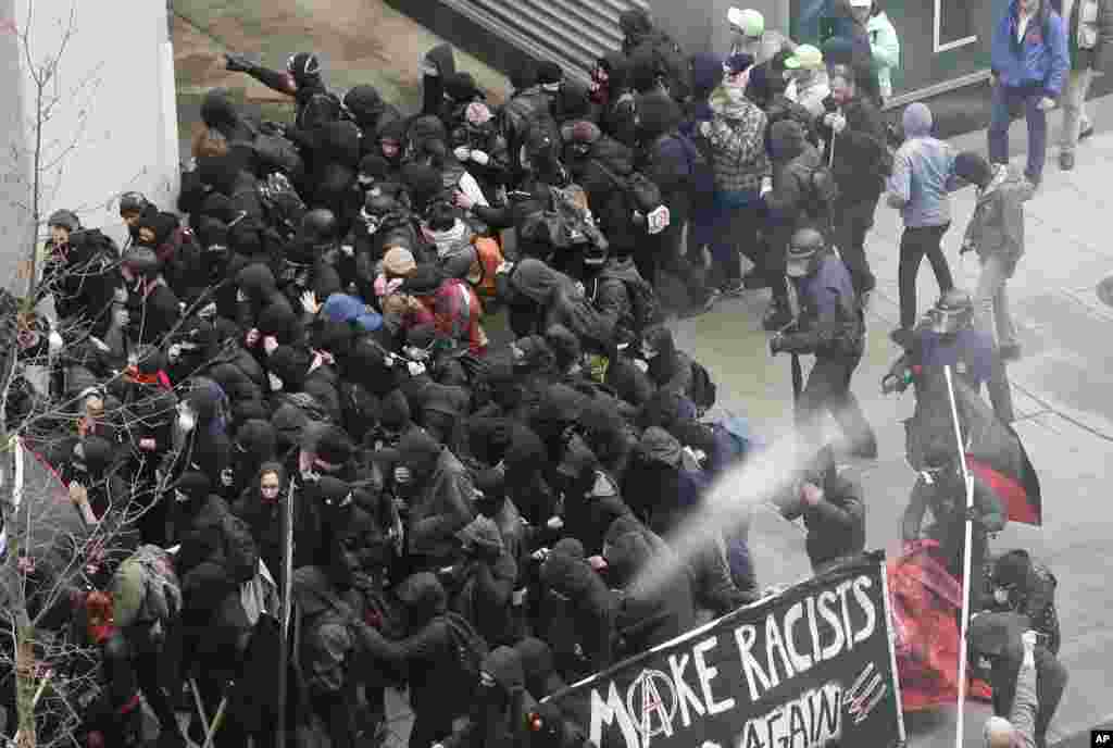 Police use pepper spray on protesters in Washington, Friday, Jan. 20, 2017, in a chaotic confrontation blocks from Donald Trump's inauguration as protesters registered their rage against the new president.