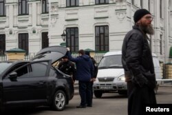 Police officers check a car next to the entrance to compound of the Kyiv Pechersk Lavra monastery, amid Russia's attack on Ukraine, in Kyiv, Ukraine March 16, 2023. (REUTERS/Valentyn Ogirenko)
