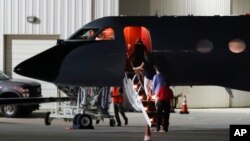 Visitors and medical personnel enter a transport plane carrying Otto Warmbier, before he is transferred to an ambulance at Lunken regional airport, June 13, 2017, in Cincinnati, Ohio.