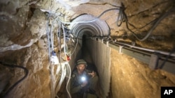 An Israeli army officer shows journalists a tunnel reportedly used by Palestinian militants for cross-border attacks from Gaza into Israel, July 25, 2014.