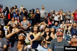 FILE - People watch the solar eclipse on the lawn of Griffith Observatory in Los Angeles, California, U.S., August 21, 2017. (REUTERS/Mario Anzuoni/File Photo)