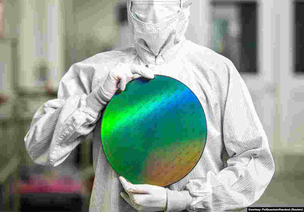 An employee of startup PsiQuantum holds a silicon disc containing the company's quantum computing chips at a facility in San Jose, California, in an undated handout photo provided on February 25, 2025.