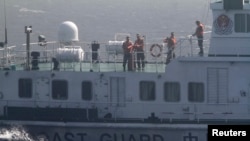Crew members onboard a Chinese coast guard vessel are pictured on the South China Sea,